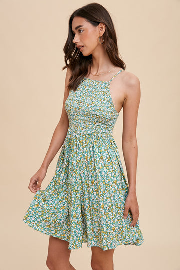 woman wearing a green floral sundress with a fitted bodice and flared skirt