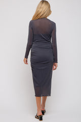 woman wearing a dark gray long sleeve maternity dress with ruching detail at the back