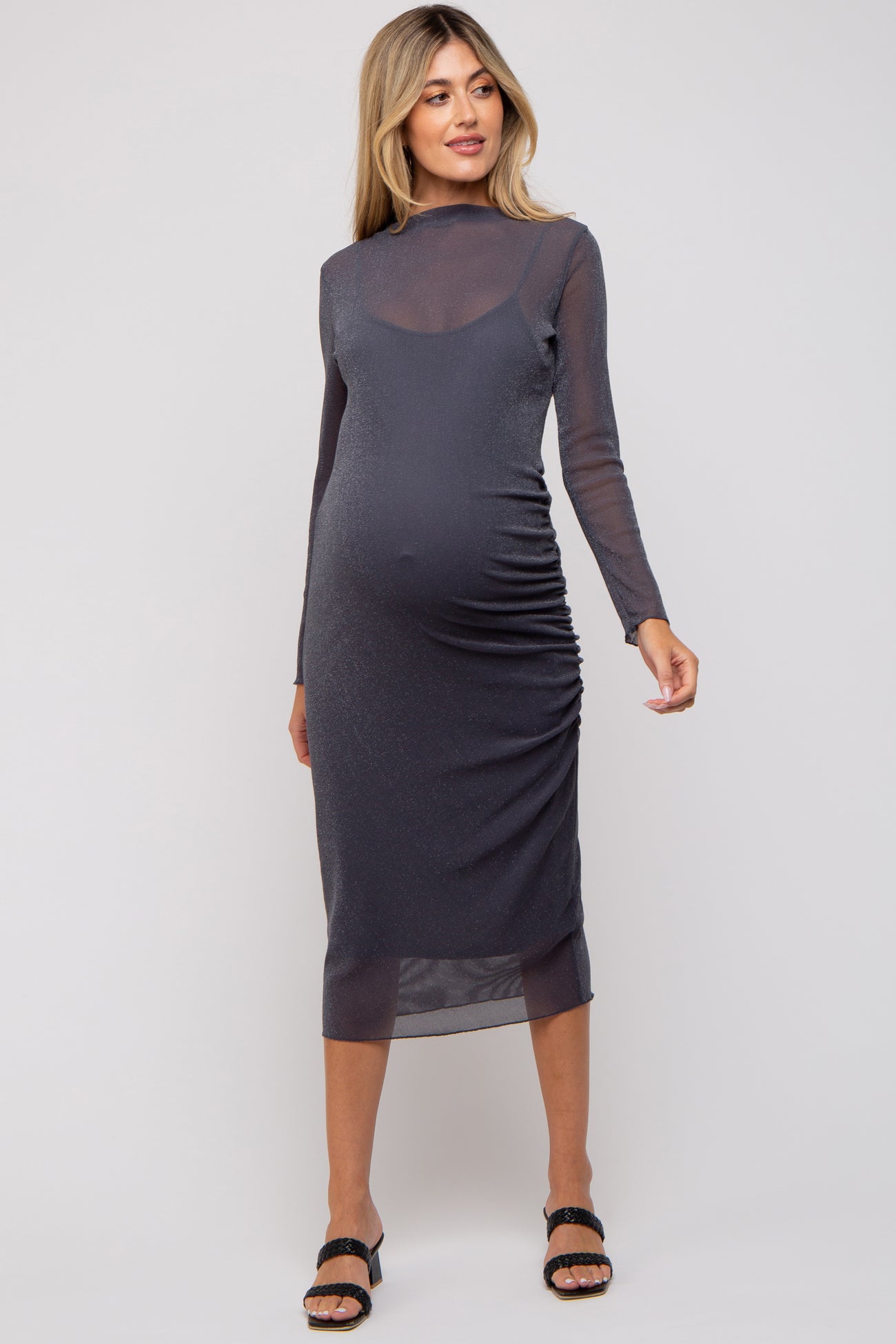 woman wearing a dark gray long sleeve maternity dress with ruched detailing and a form-fitting silhouette, showcasing a baby bump