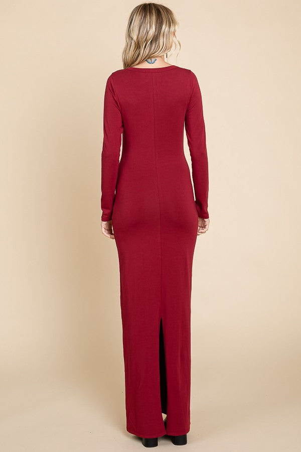 woman wearing a burgundy long sleeve form-fitting maxi dress with a back slit