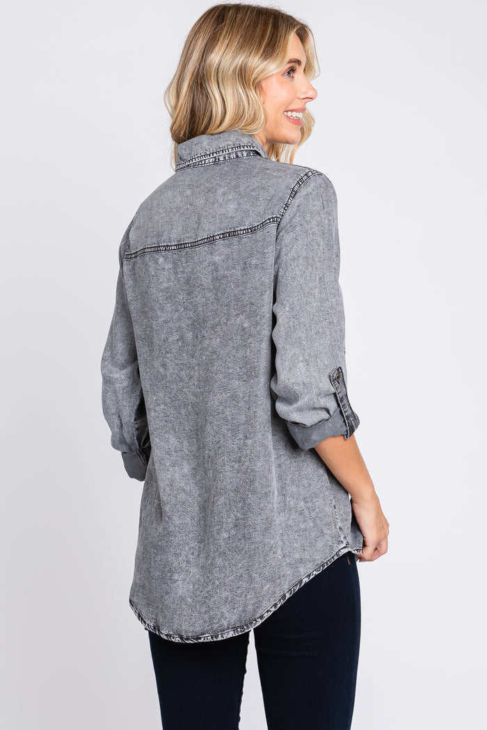 woman wearing a gray long sleeve denim shirt with rolled sleeves and curved hem, shown from the back