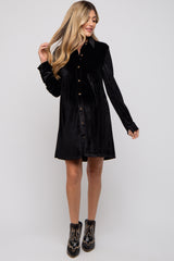 woman wearing a black velvet maternity dress with button-up details and long sleeves