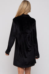 woman wearing a black velvet maternity dress with a gathered back detail and long sleeves