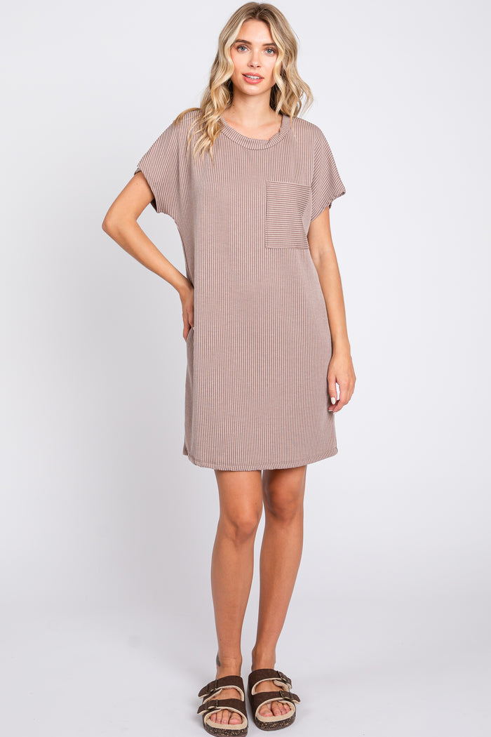 woman wearing a brown striped short sleeve dress with a chest pocket and standing in a relaxed pose