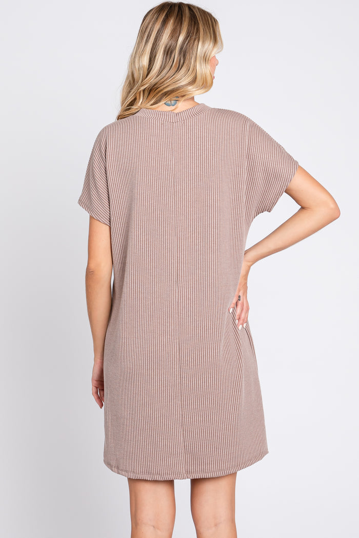 woman wearing a brown striped short sleeve dress, showing the back view and knee-length style