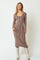 woman wearing a long sleeve ribbed midi dress in brown and beige stripes with knee-high white boots
