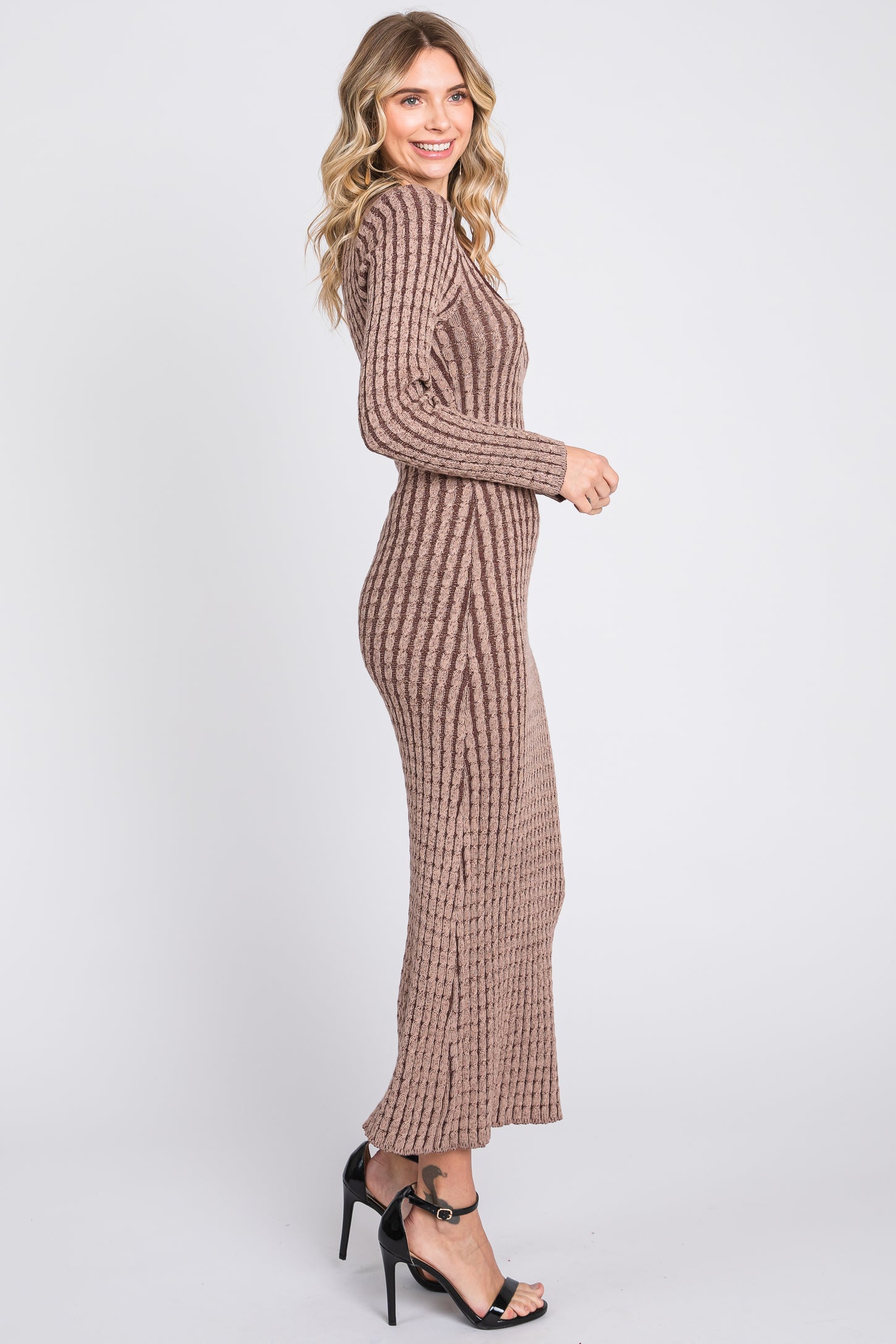 woman wearing a ribbed brown long sleeve maxi dress and black heeled sandals, posing in profile