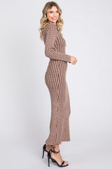 woman wearing a ribbed brown long sleeve maxi dress and black heeled sandals, posing in profile