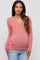 woman wearing a pink long sleeve maternity top with a v-neck and visible baby bump