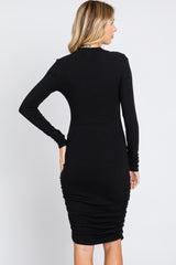 woman wearing a black long sleeve bodycon dress with ruched details at the back
