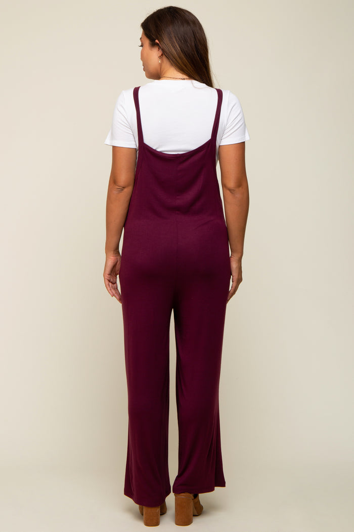 woman wearing a burgundy maternity jumpsuit with wide legs, shown from the back