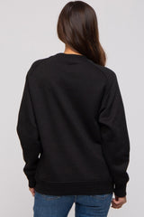 woman wearing a black maternity sweatshirt from the back with long sleeves and a relaxed fit