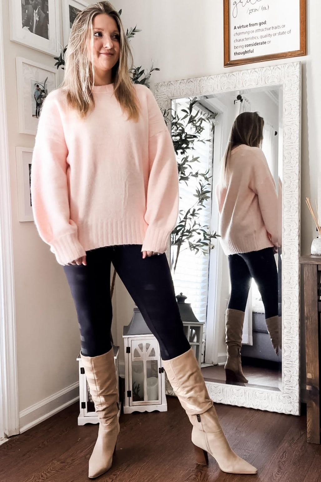 woman wearing a soft pink oversized sweater with balloon sleeves, paired with black leggings and beige knee-high boots