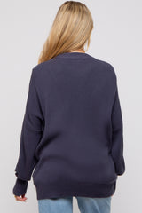 woman wearing a navy blue oversized maternity sweater with ribbed details and long sleeves