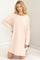 woman wearing a light pink oversized long sleeve dress with side slits