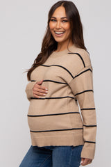 woman wearing a tan striped maternity sweater and holding her baby bump