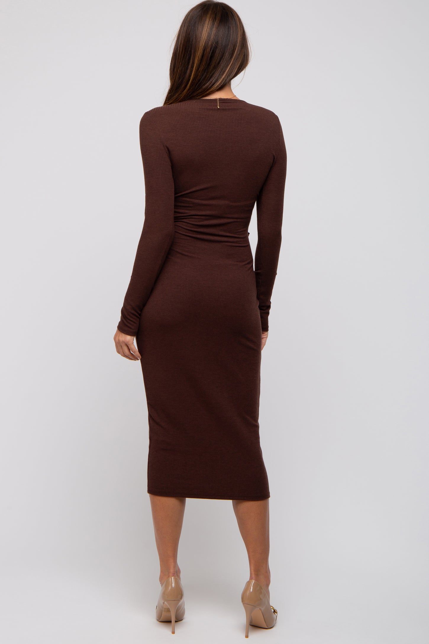 woman wearing a form-fitting brown ribbed long sleeve midi dress, seen from the back