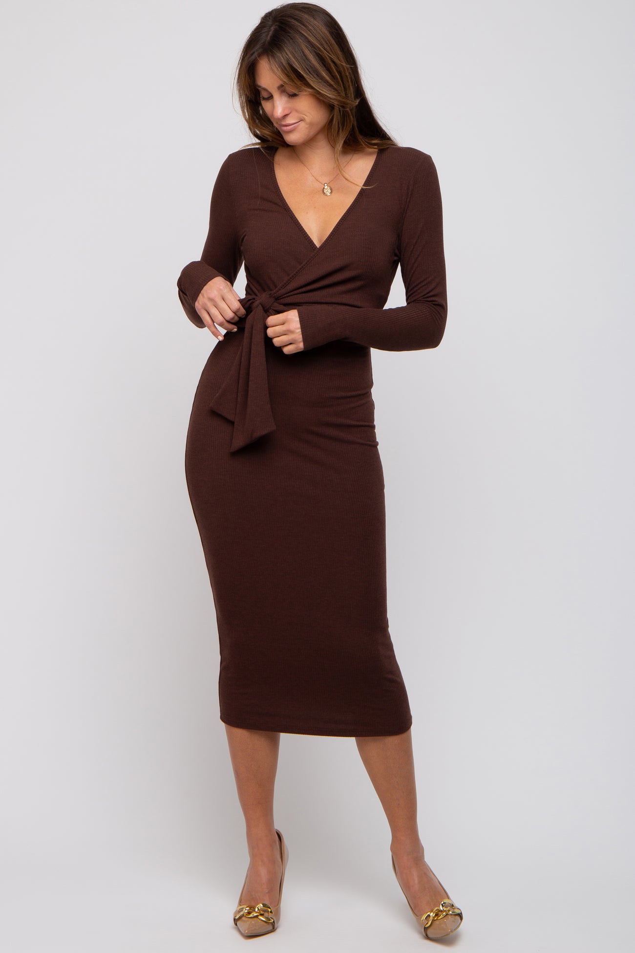woman wearing a brown wrap midi dress with long sleeves and a tie detail at the waist