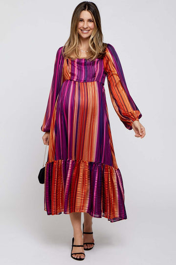 woman wearing a purple and orange striped maternity dress with long sleeves and a ruffled hem, and showing her baby bump