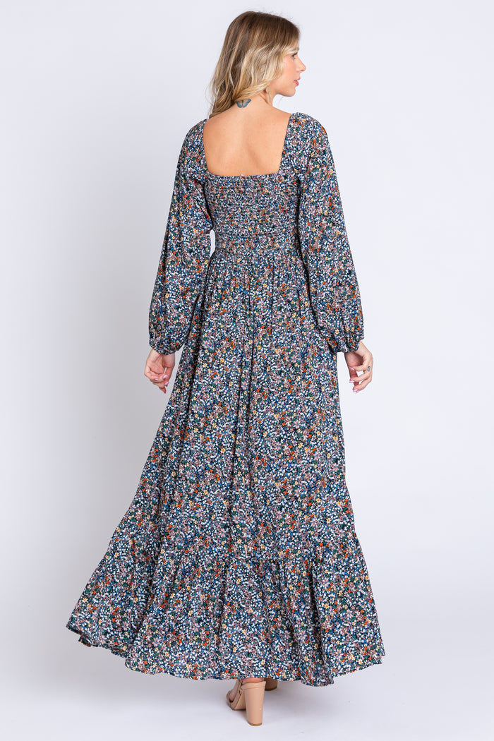 woman wearing a long floral maxi dress with a square neckline and long puff sleeves, showing the back view