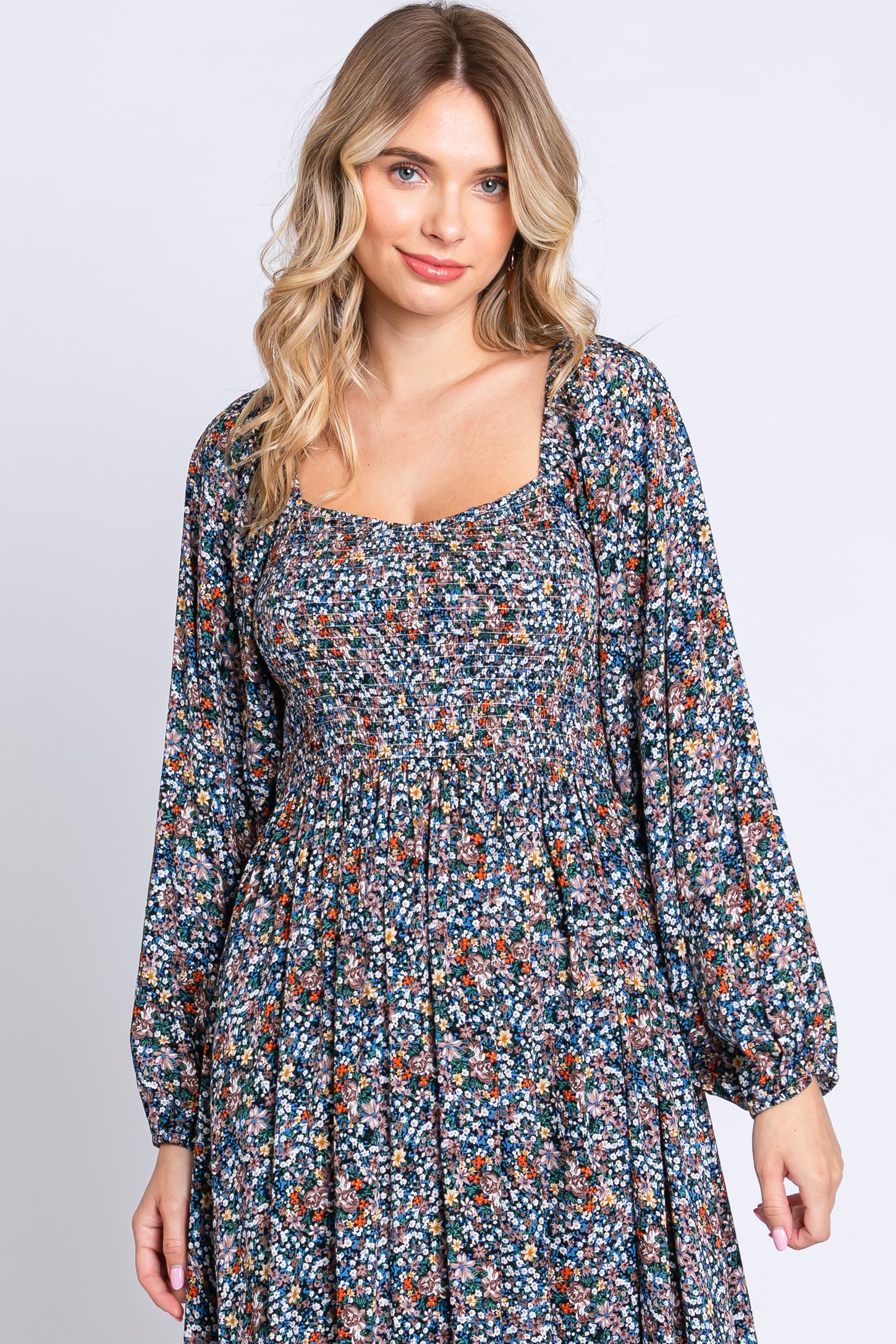 woman wearing a floral print long sleeve maxi dress with a square neckline and smocked bodice