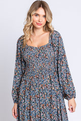 woman wearing a floral print long sleeve maxi dress with a square neckline and smocked bodice