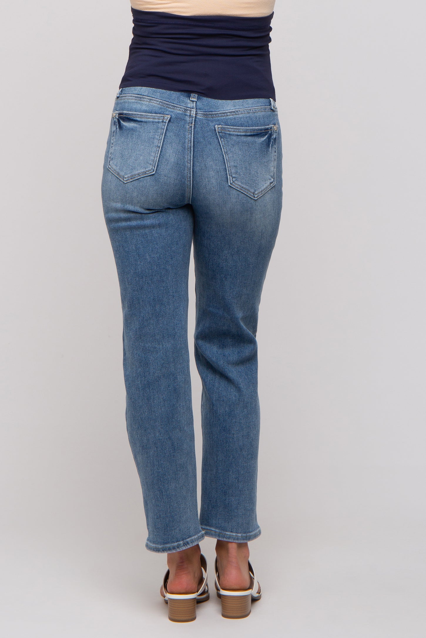 woman wearing a pair of light blue straight leg maternity jeans, viewed from the back