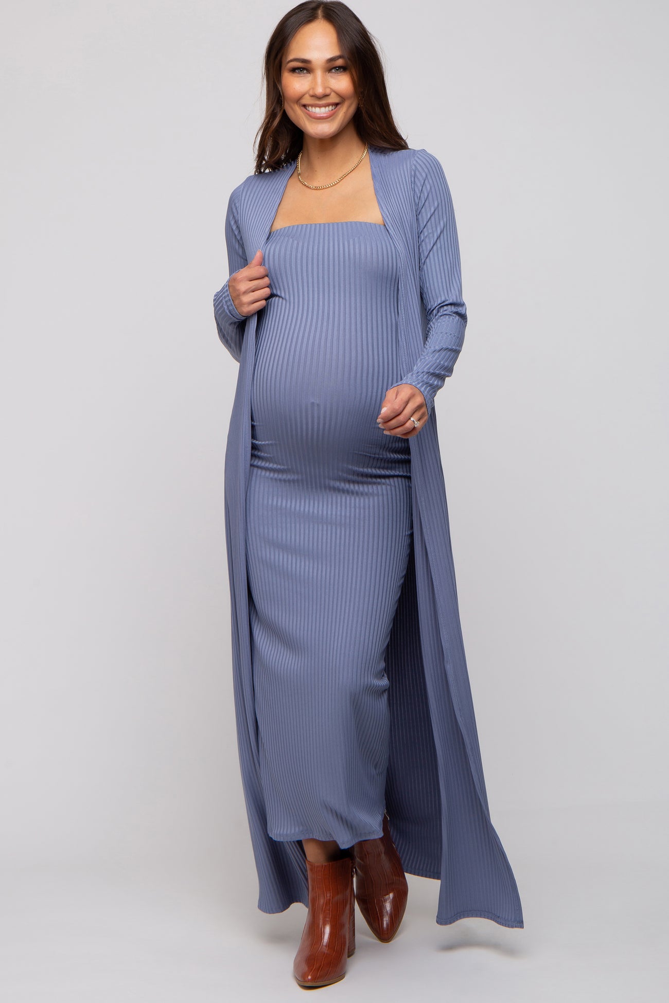 woman wearing a light blue ribbed maternity maxi dress with a matching duster and showing her baby bump