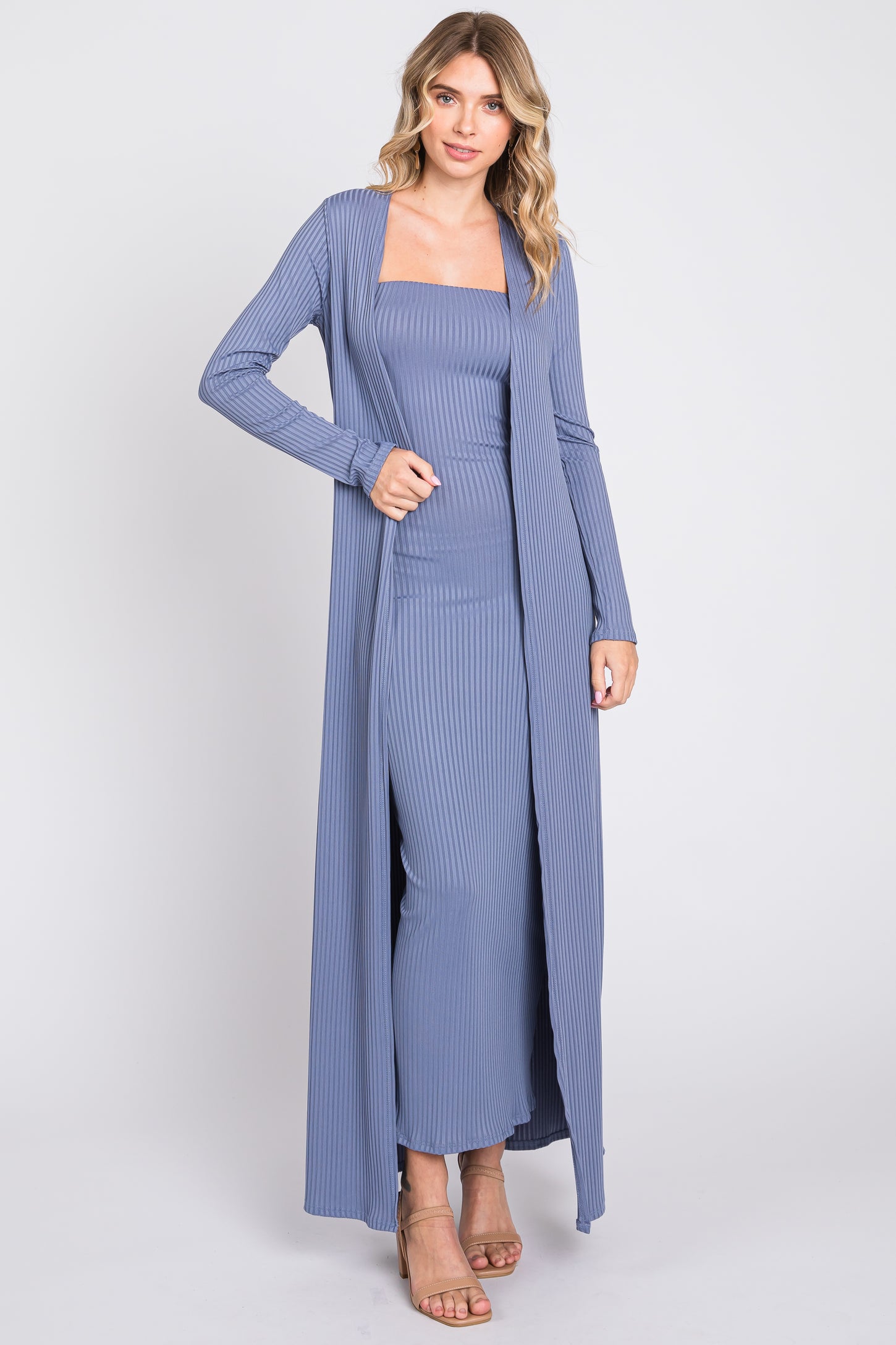 woman wearing a light blue ribbed maxi dress with long cardigan and strappy heels
