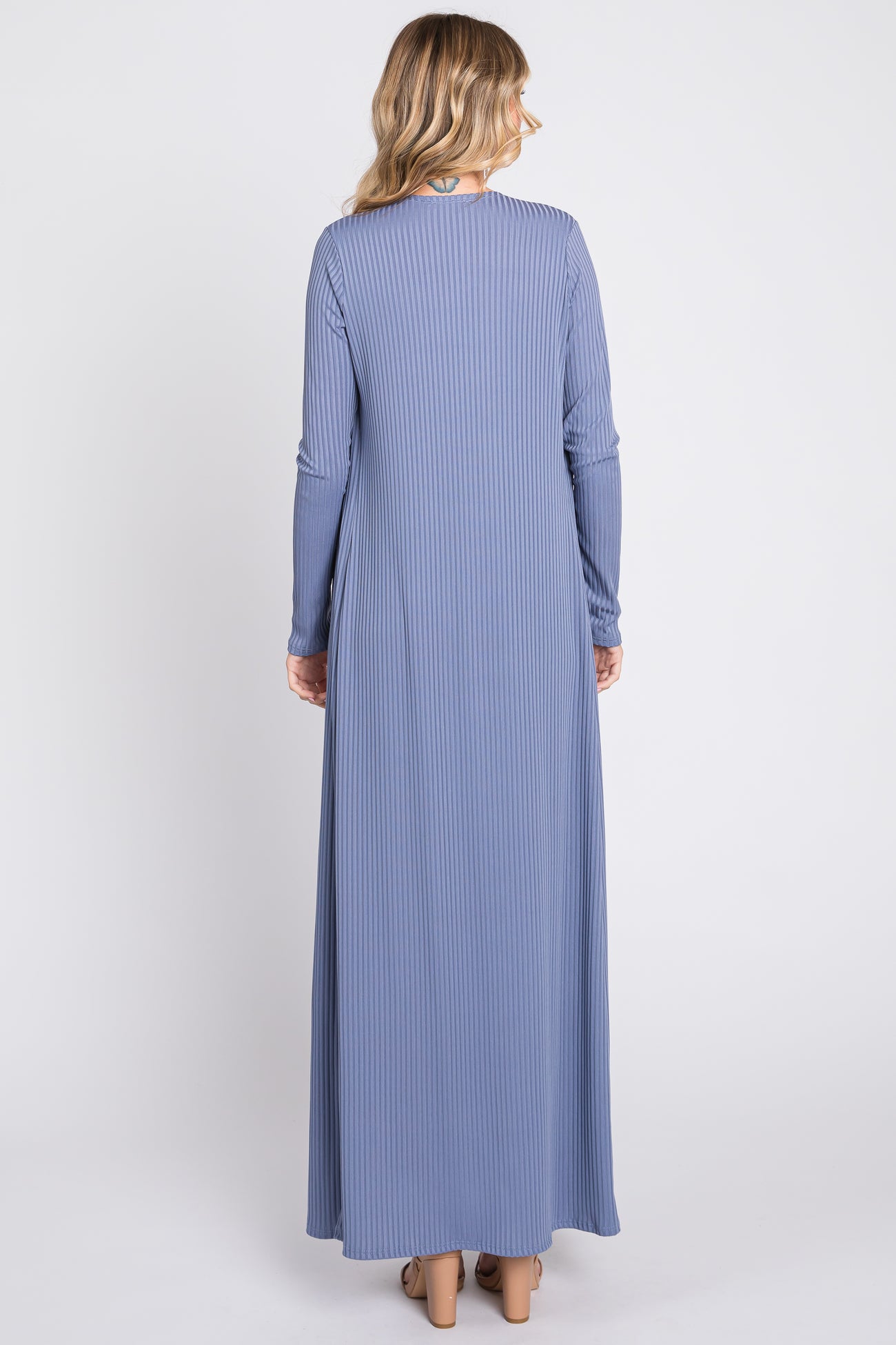 woman wearing a ribbed long sleeve maxi dress in soft blue, showing the back view with a flowy silhouette.