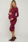 woman wearing a burgundy long sleeve maternity dress with side button details and holding her baby bump