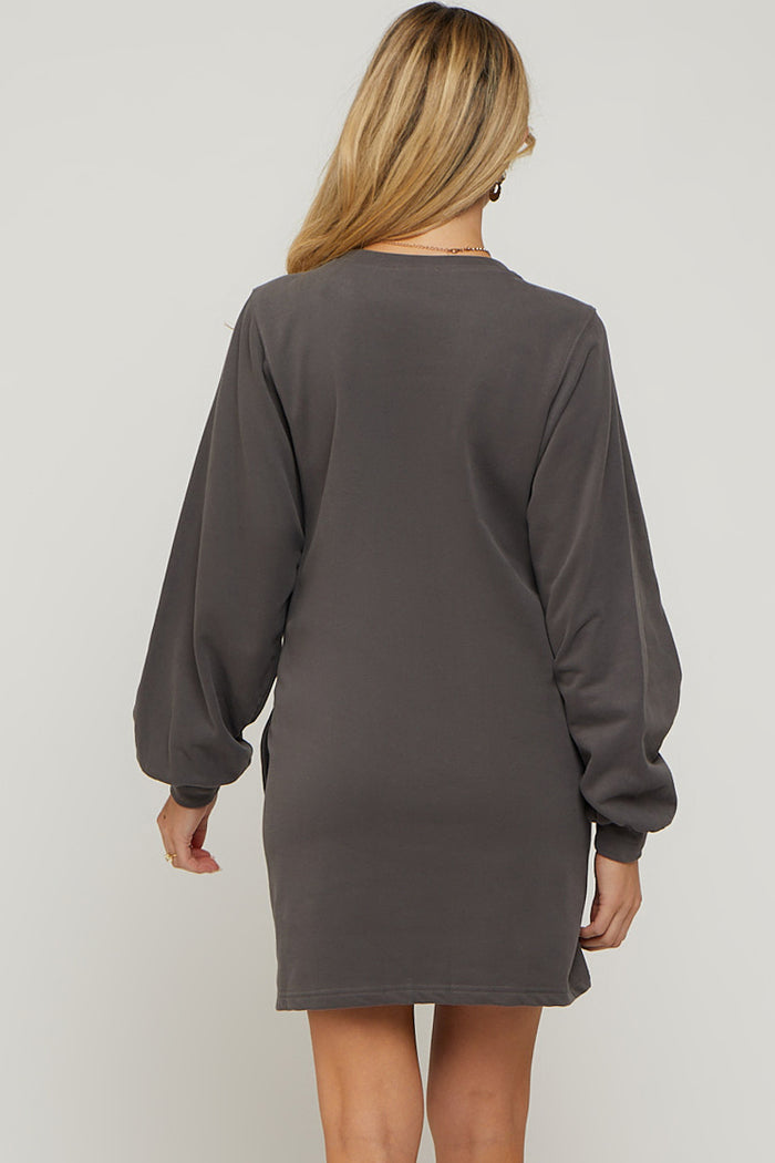 woman wearing a dark gray maternity sweater dress with long balloon sleeves, showing the back view