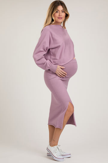 woman wearing a lavender cropped sweatshirt and a matching midi skirt, showing her baby bump