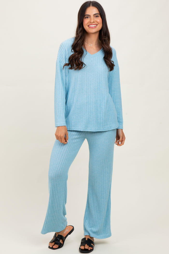 woman wearing a light blue ribbed loungewear set with a v-neck long sleeve top and wide leg pants