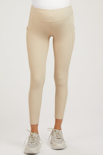 maternity wear in beige ribbed leggings with side pockets, model wearing sneakers