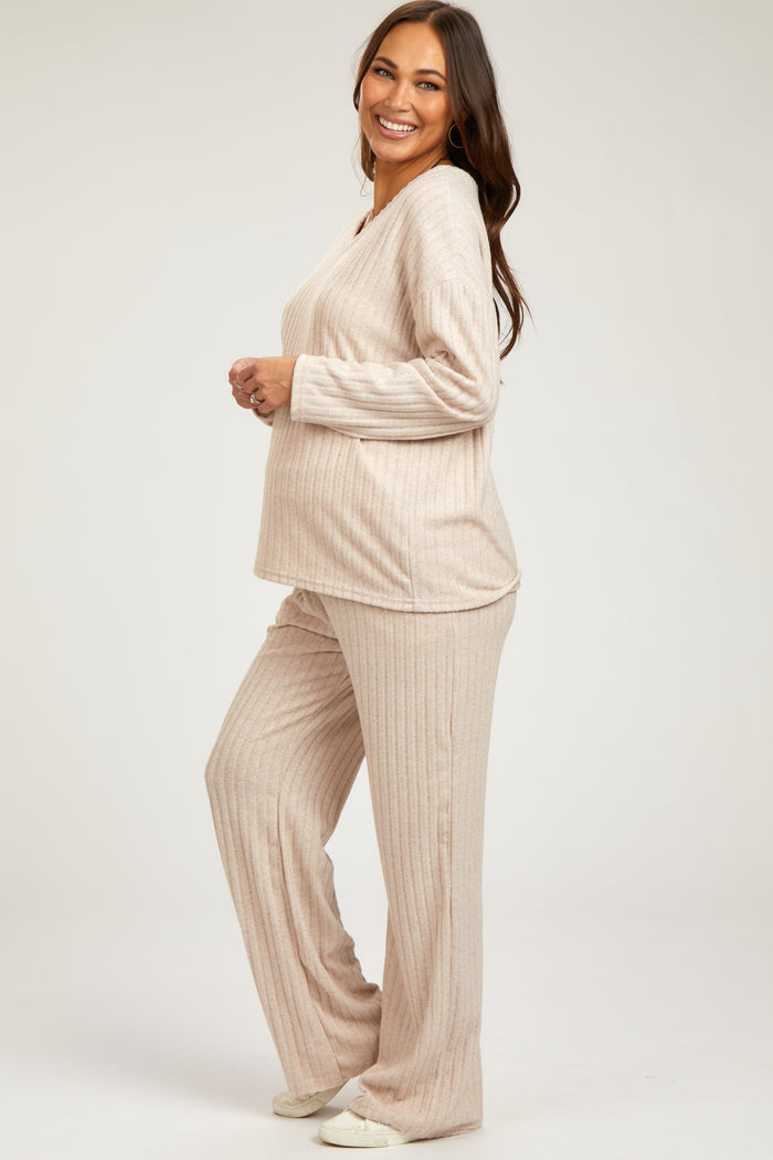 woman wearing a beige ribbed maternity loungewear set with a visible baby bump and long sleeves
