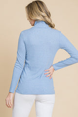 woman wearing a light blue turtleneck sweater with long sleeves and a fitted style, viewed from the back