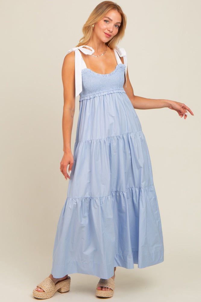 woman wearing a light blue tiered maxi dress with smocked bodice and shoulder ties