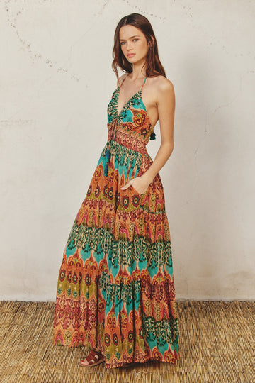 woman wearing a multicolored halter maxi dress with a patterned design and pockets