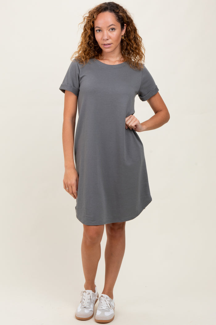 woman wearing a gray short sleeve dress with a pocket and styled with white sneakers