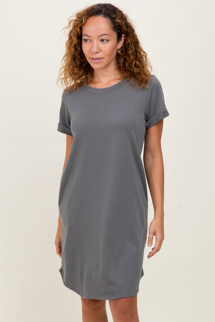 woman wearing a gray short sleeve t-shirt dress with rolled sleeves and a relaxed fit