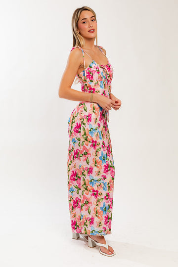 woman wearing a pink floral print maxi dress with spaghetti straps and a tie front detail