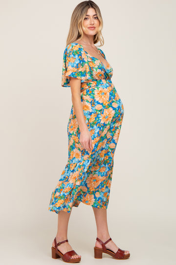 woman wearing a floral maternity dress with a v-neckline and short sleeves, showing her baby bump