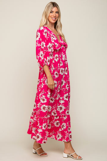 woman wearing a bright pink floral maxi dress with puffed sleeves and a tiered skirt