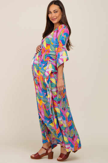 woman wearing a vibrant multi-colored maternity dress with three-quarter sleeves and a baby bump visible
