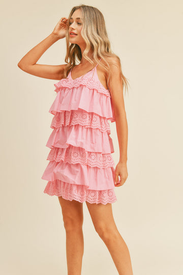 woman wearing a pink tiered ruffled dress with eyelet details and spaghetti straps
