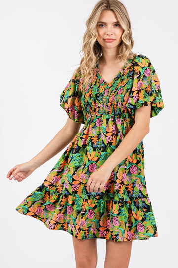 woman wearing a colorful floral print short dress with puff sleeves and a smocked bodice